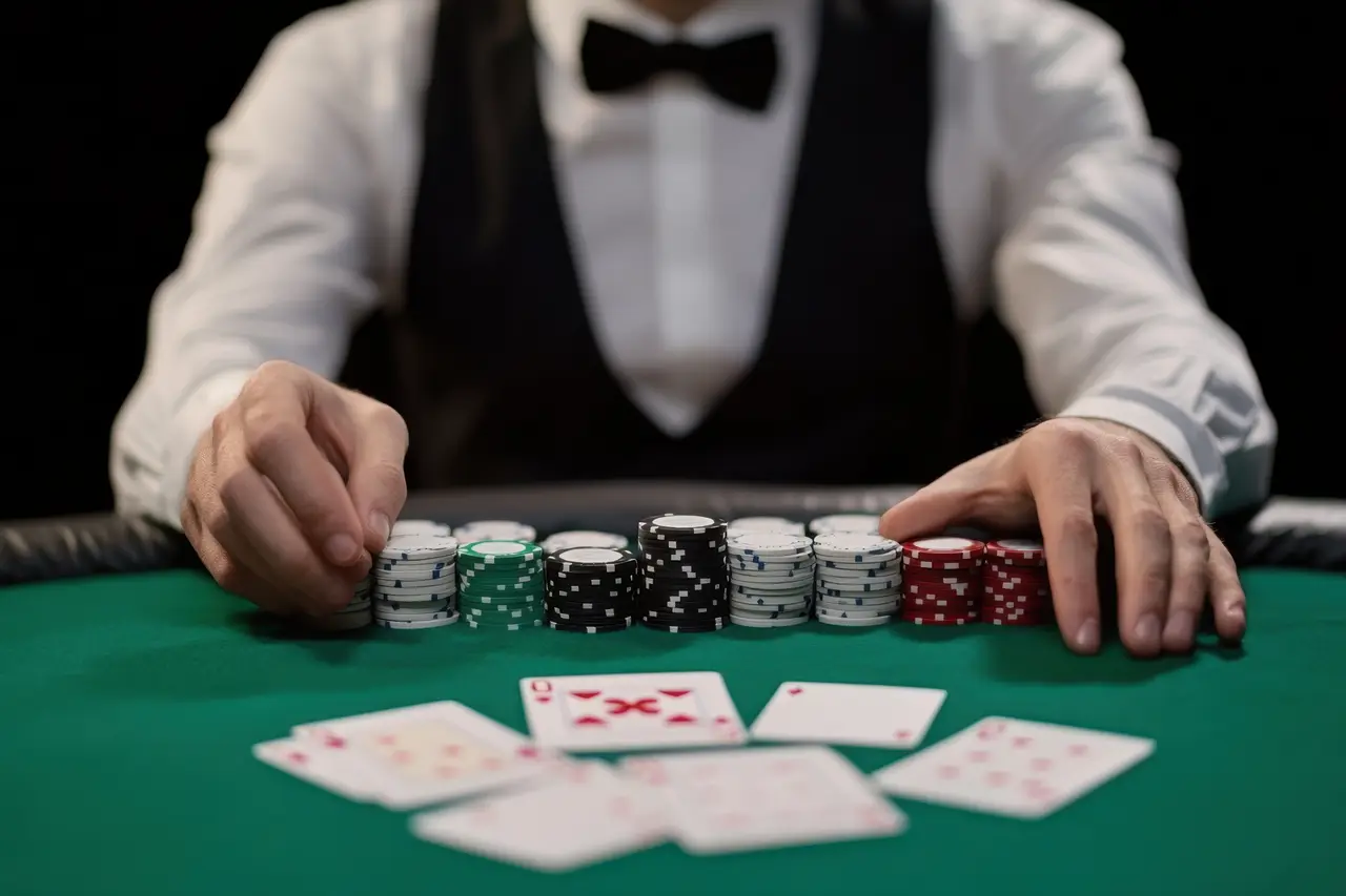 Croupier derrière des piles de jetons et des cartes sur un tapis vert